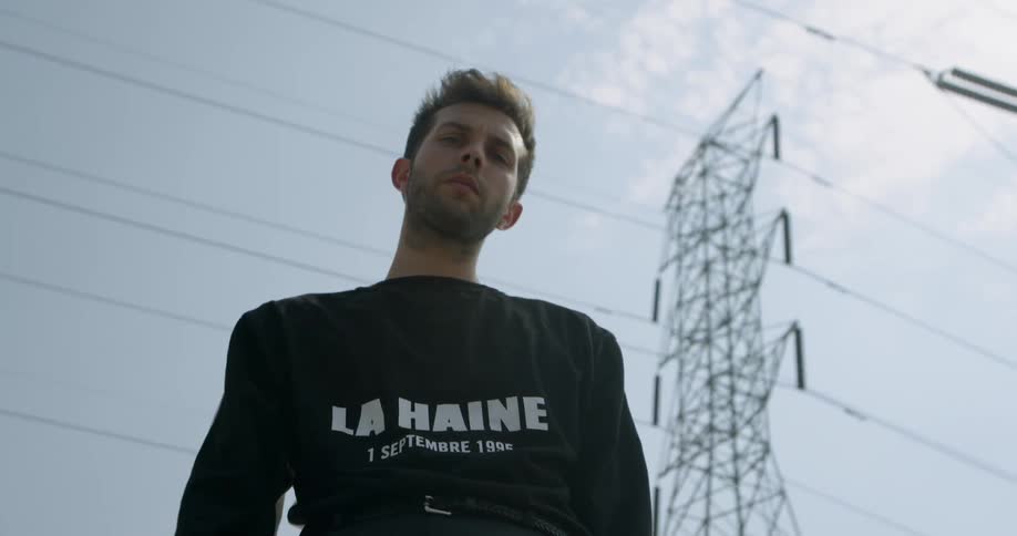 A man stands under the power lines