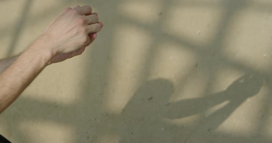 The person makes shadow puppets on the wall