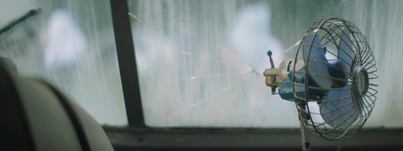 People dance outside of a house with a broken window