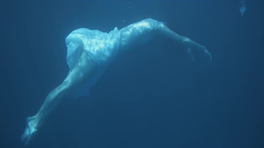 The woman is floating under the dark water