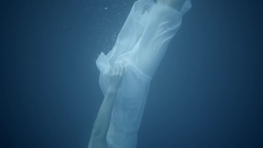 A woman is floating beneath the water in daylight