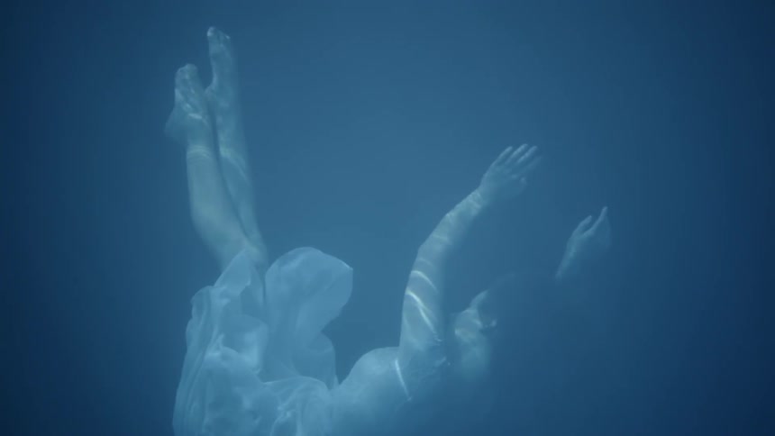 A woman is swimming underneath the water