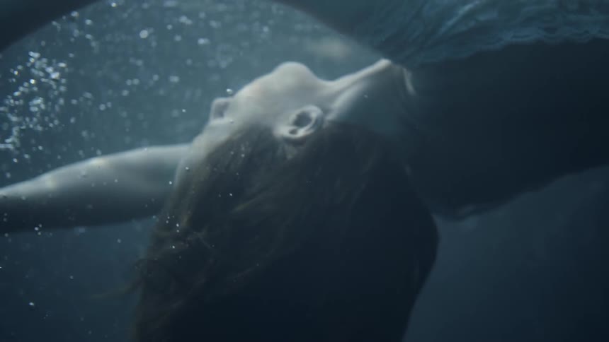 A woman is floating underwater