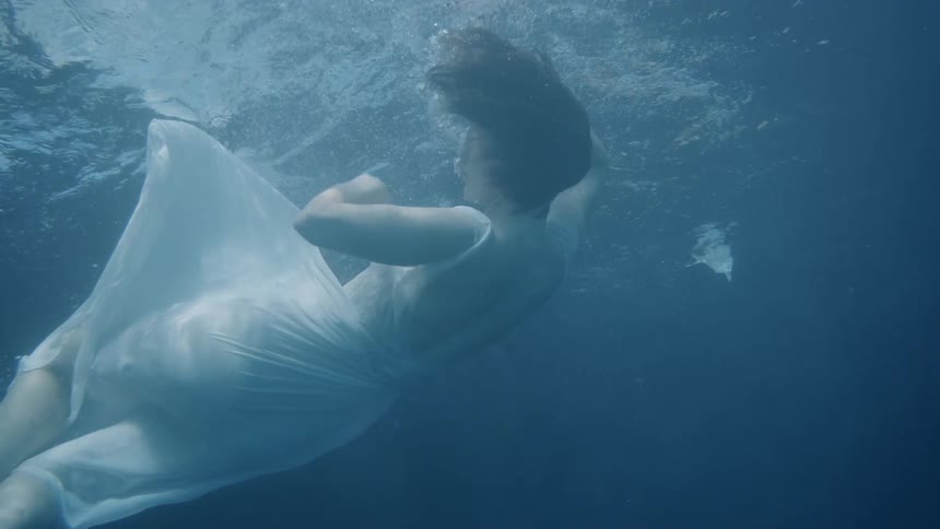 A woman dives falling under the water