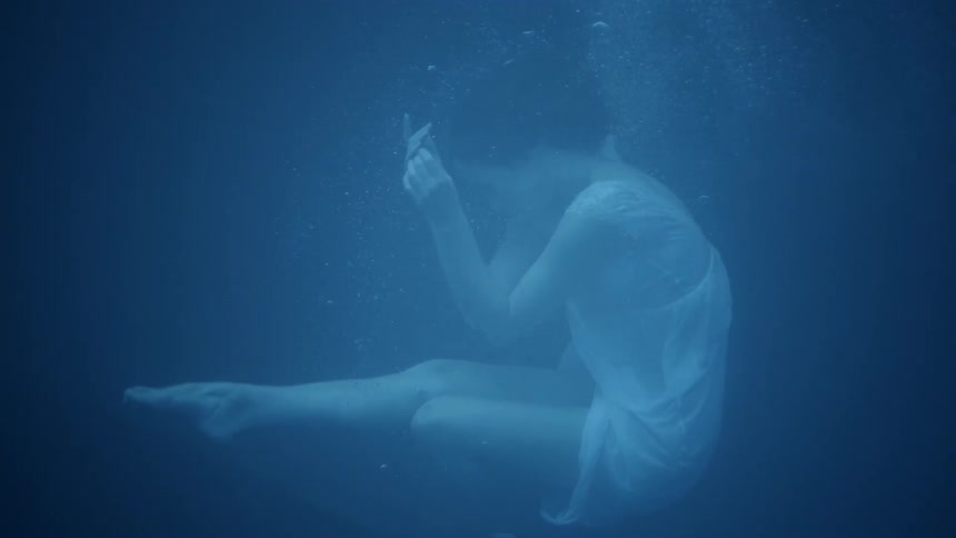 A woman floats to the surface of the water