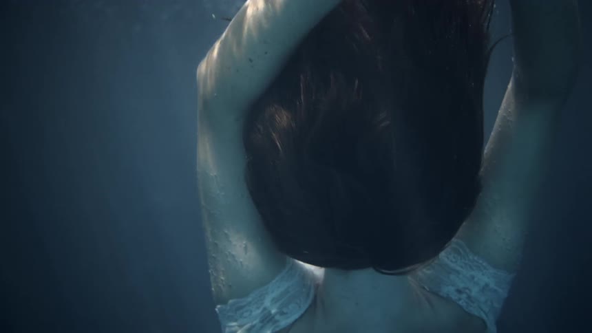 A woman is floating under the water