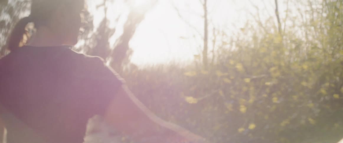 A woman walks in a meadow on a sunny day