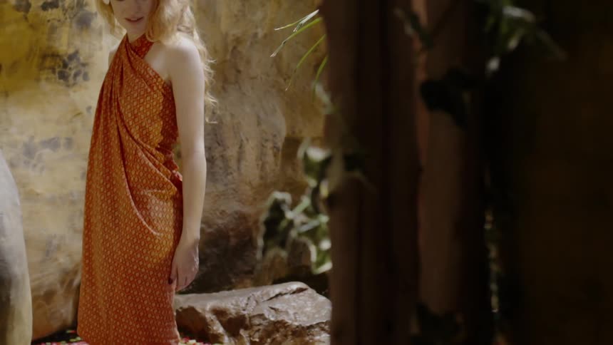 The woman turns around in the flower filled water