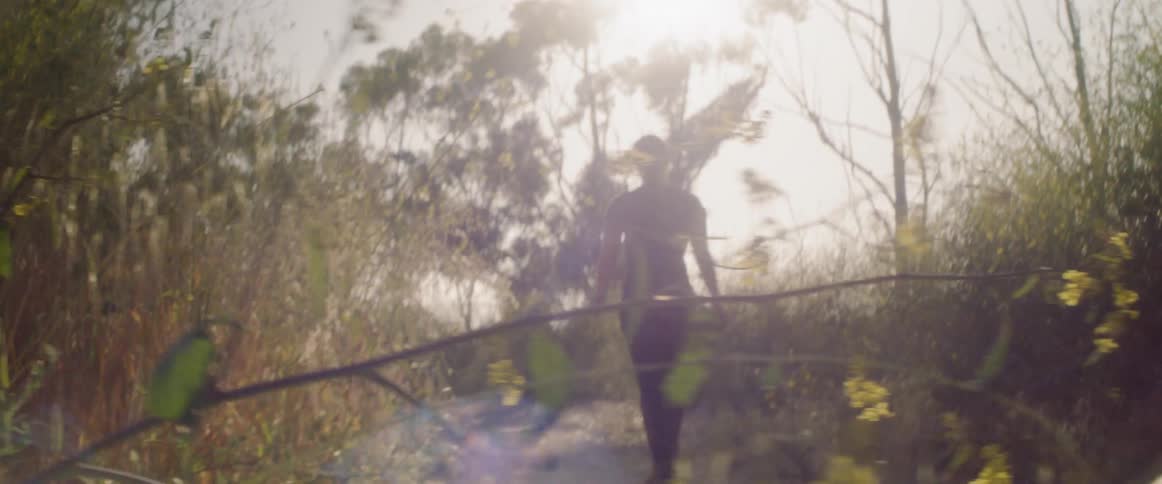 Woman walks down a path under the bright sun