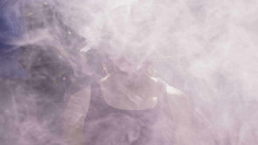 Man stands still as smoke floats around him