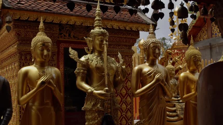 Statues are standing in a buddhist shrine in an asian country in daylight