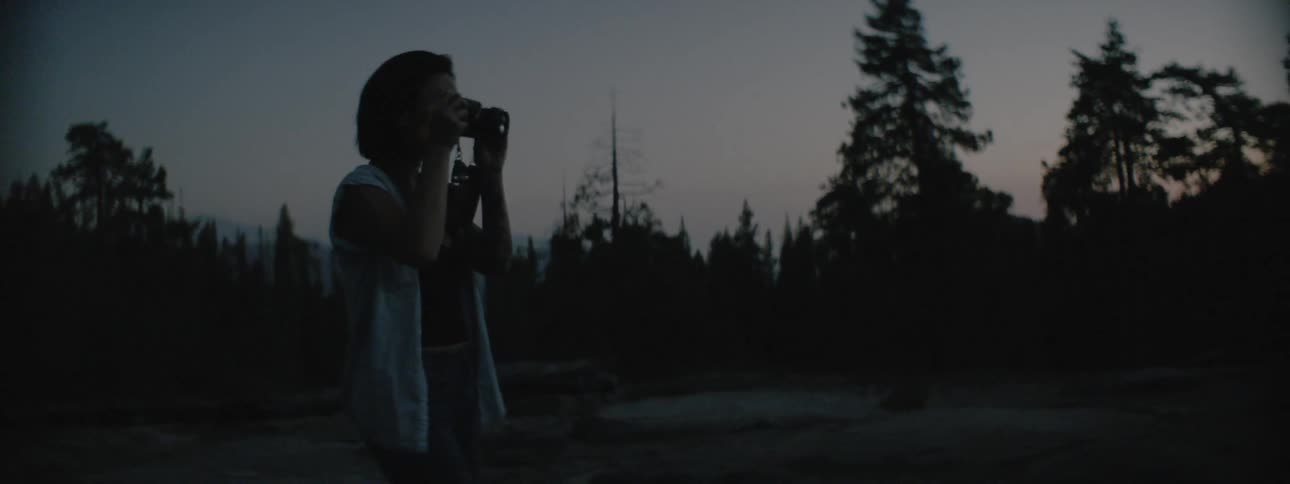 Woman takes a photo at night near the forest