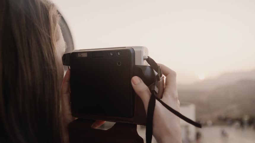 The woman is taking a photograph of hills