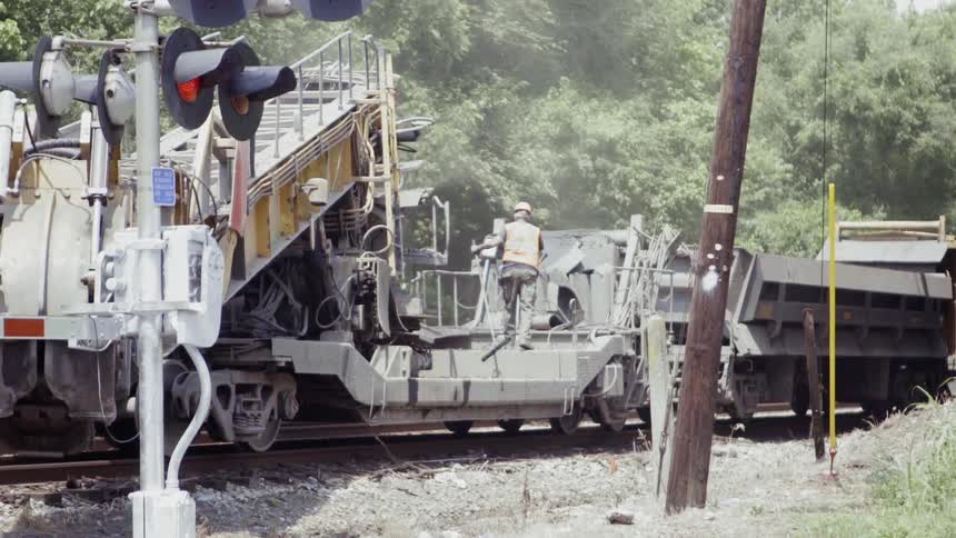 A man gets on the train on the tracks