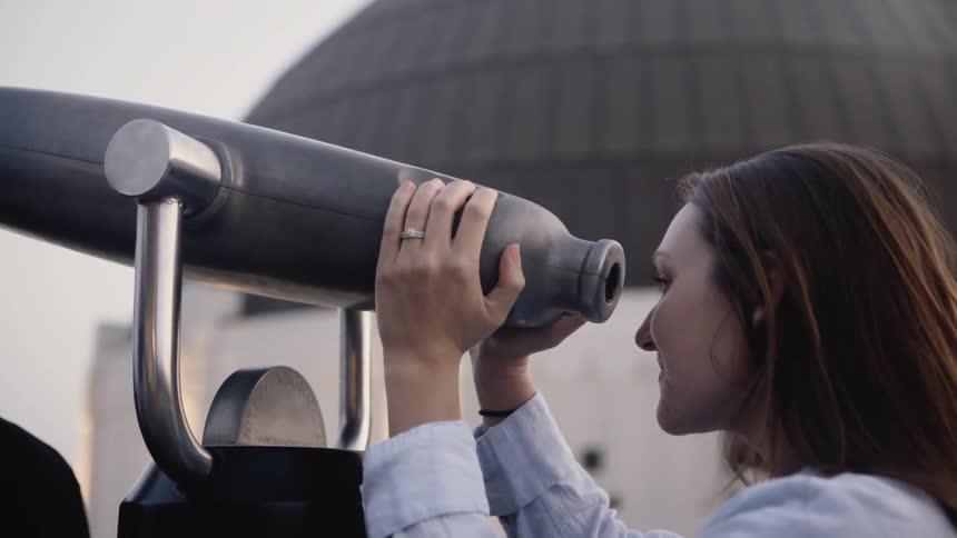 Woman looks through a large cylindrical tube