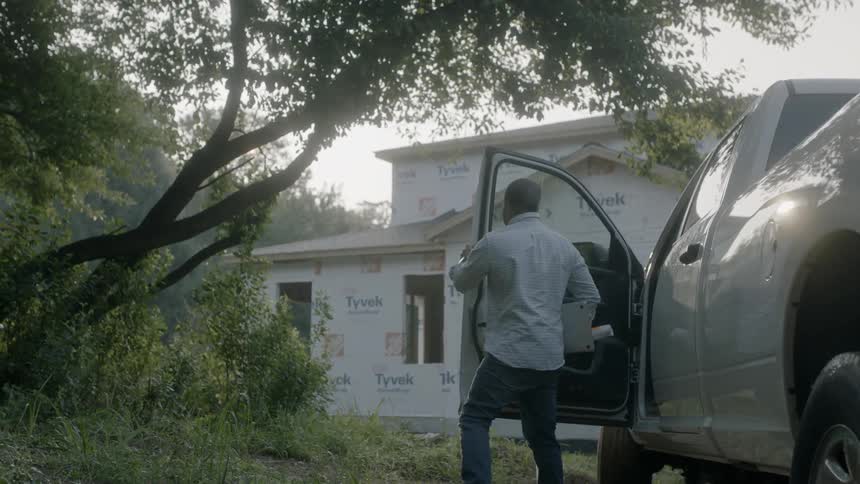 Man Looks At Blueprints For A Construction Site