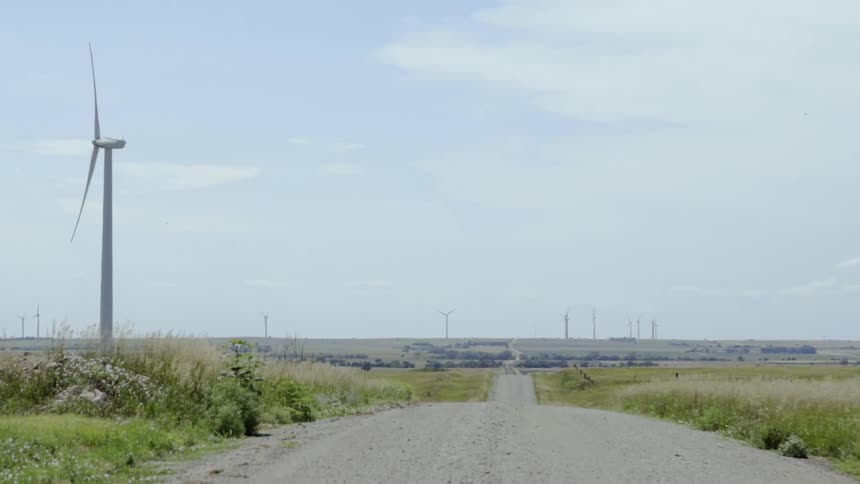 Wind turbine spins as it sits near the road