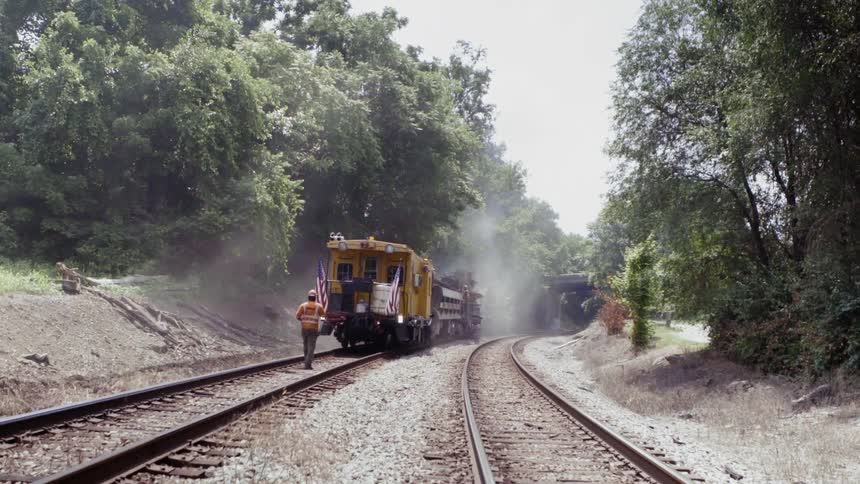 The man walks behind the slow moving train