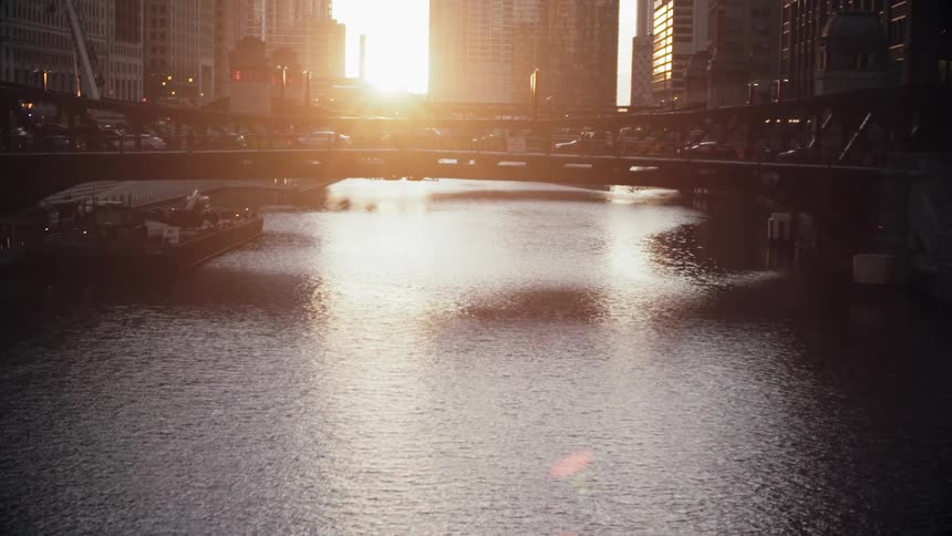 The sun sets over a city bridge