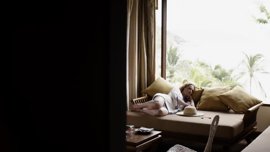 A woman relaxes on a couch with pillows