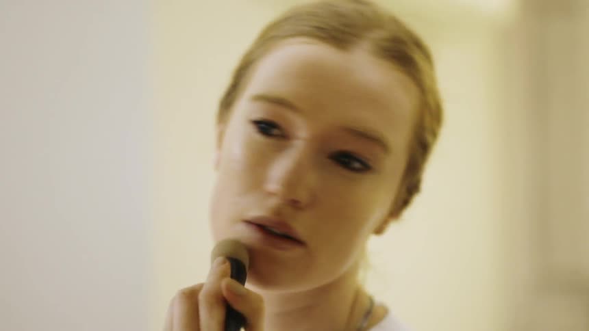 A woman applies makeup with a makeup brush
