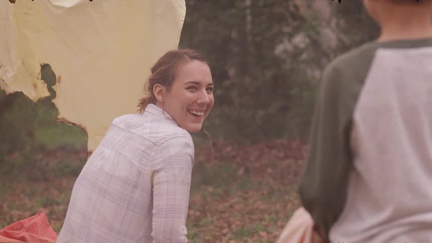 A woman smiles looking back at a child