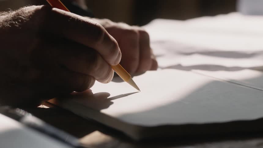 A person is writing with a pencil
