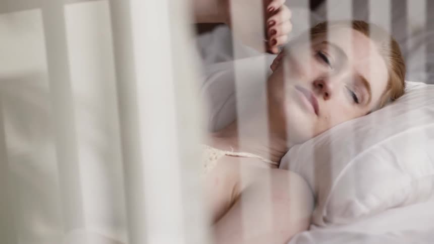 A woman lies awake in bed