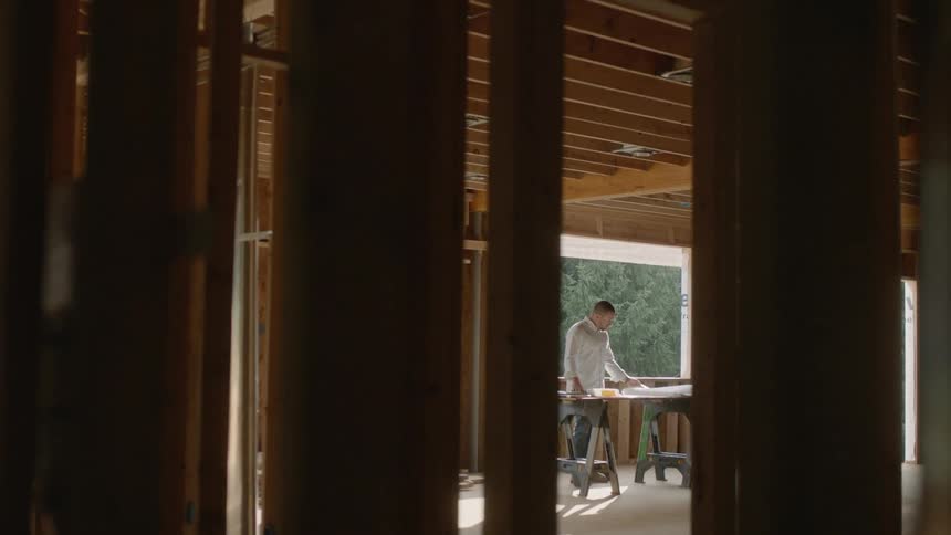 The man is working in the unfinished house