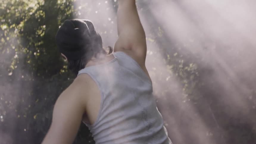 A man is dancing in the fog of the forest