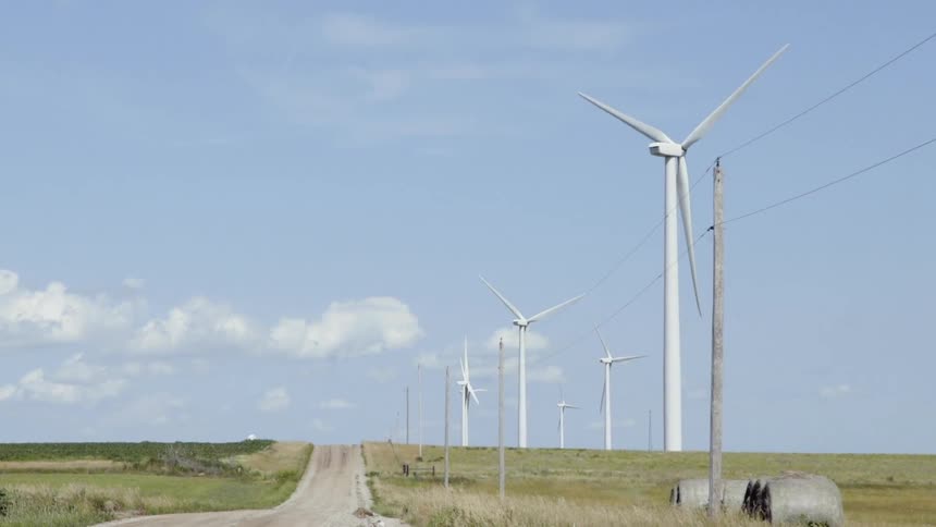 Wind turbines spin in a rural field