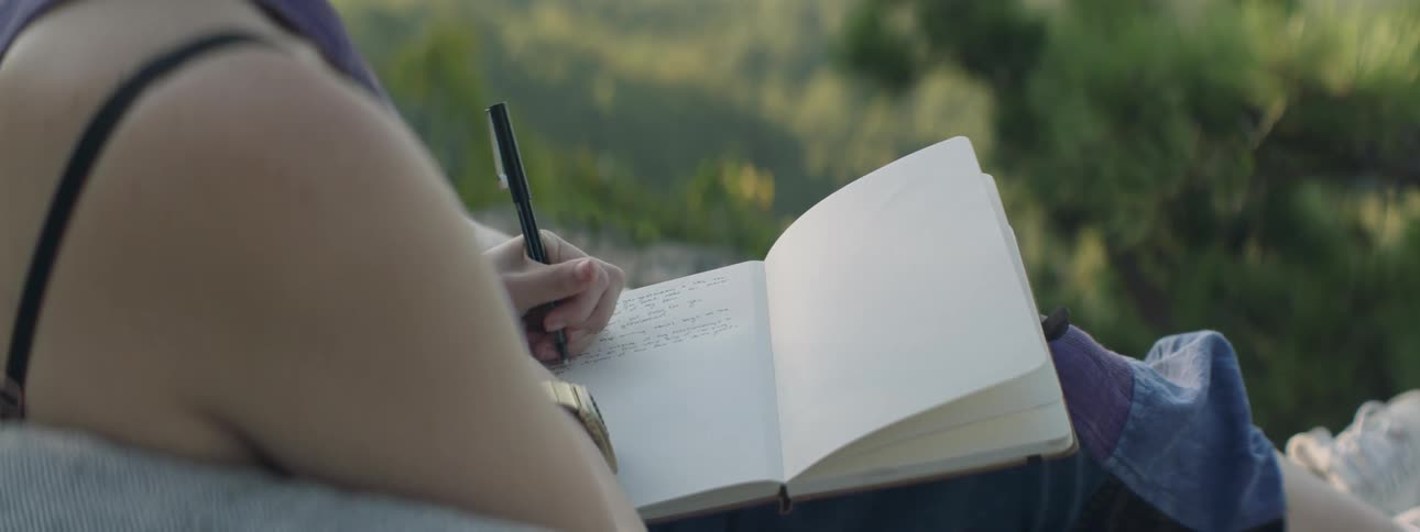 A person is writing in a notebook