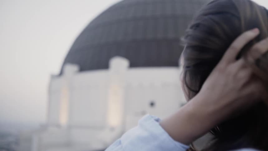 The woman looks at the view from a roof