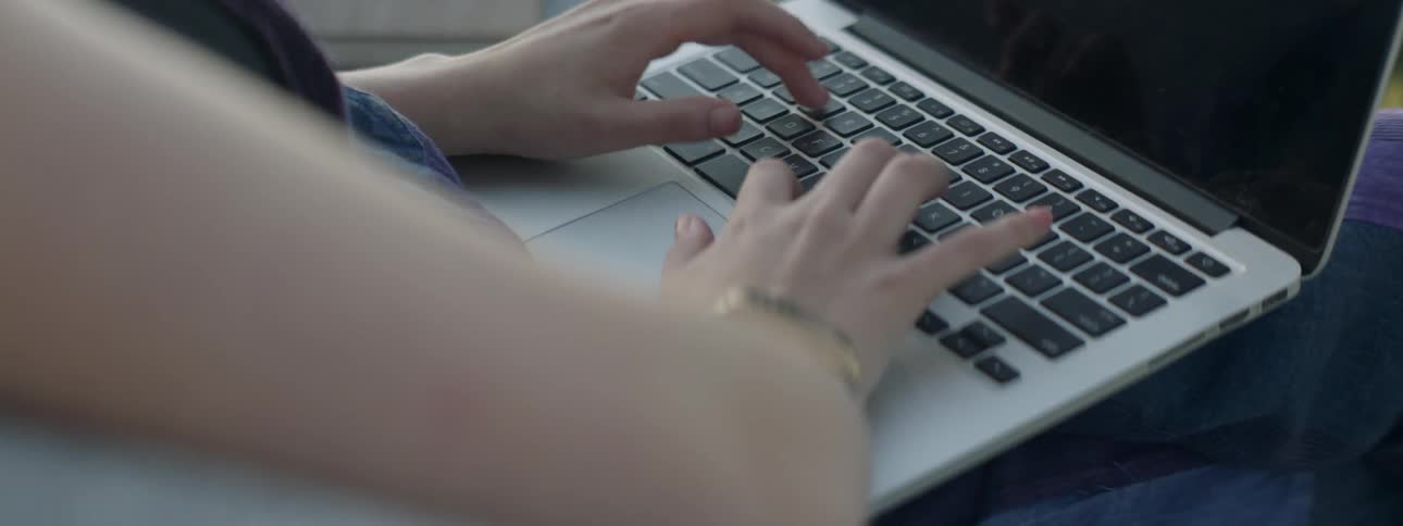 A woman types on a laptop