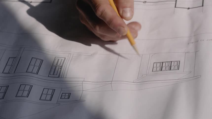 A man sketches a house design