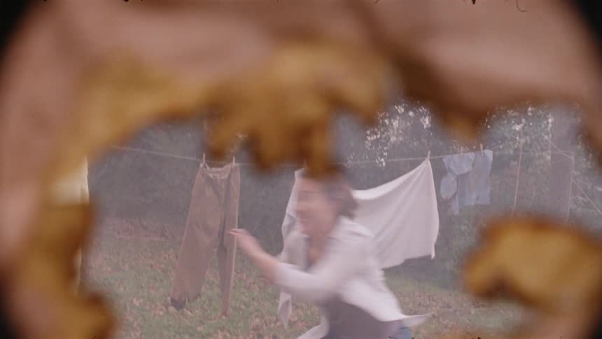 A woman races around the yard between the hanging clothes