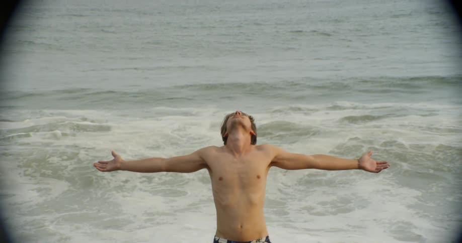 A man outstretches his arm on the beach