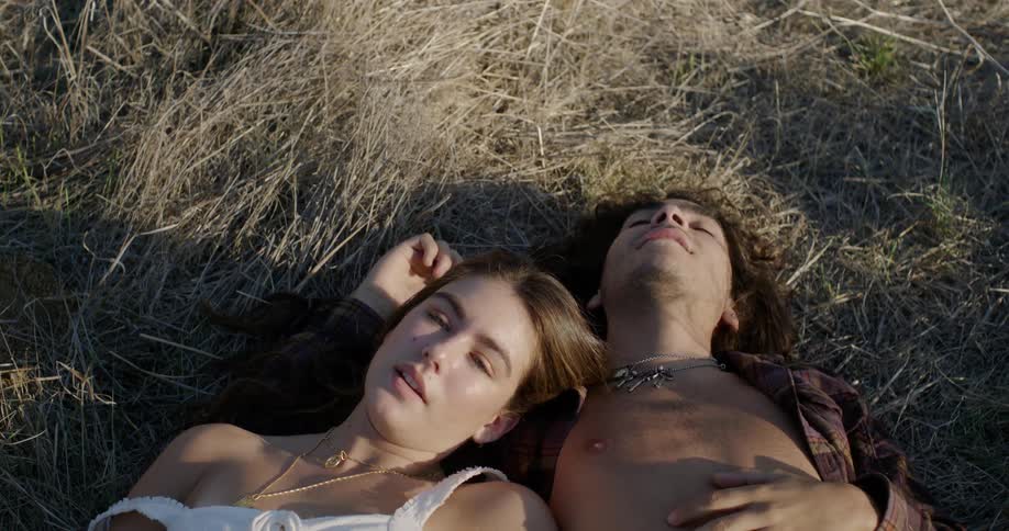 A man and woman lay in the hay