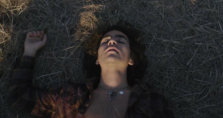 Man lays on the grass in a field