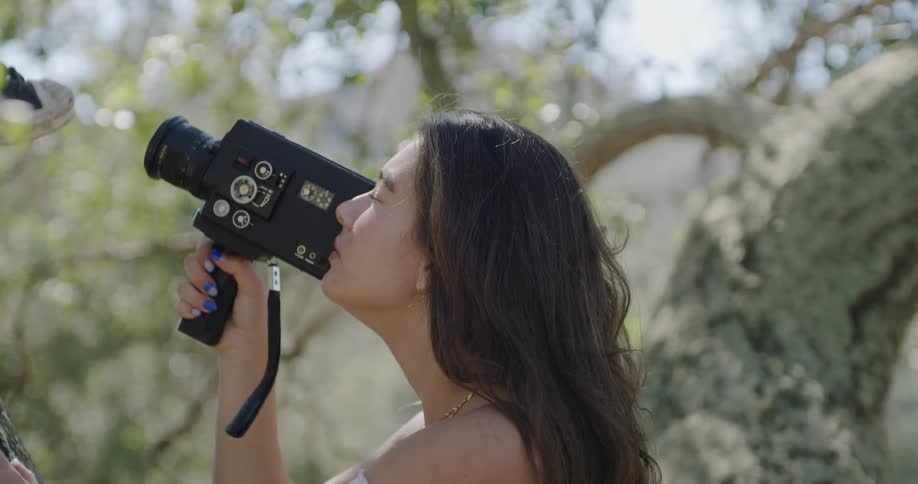 The woman is recording in the forest