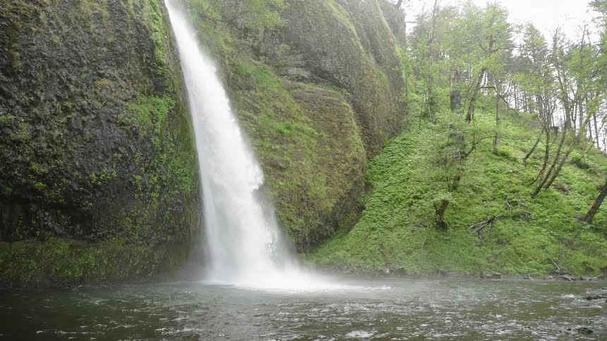 A waterfall flows into a lake in the wilderness