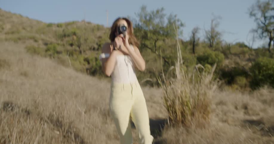 A woman is taking photographs on the field