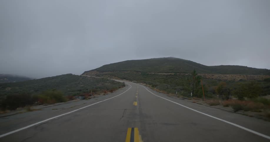 A landscape view of a road with mountains in the background
