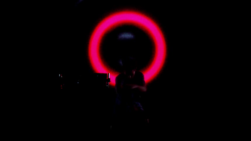 The lights are flashing in a circle behind a dancing man