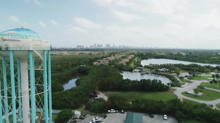 A water tower stands on the outskirts of a city