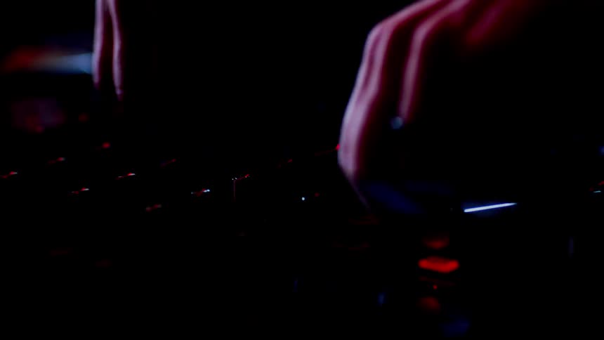 Man turns dials on an electronic device as lights flash