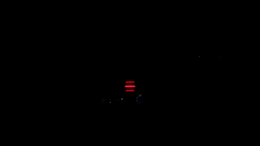 Two men perform in front of the colored lights