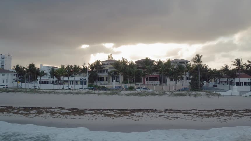 Cars drive in a coastal town at sunset
