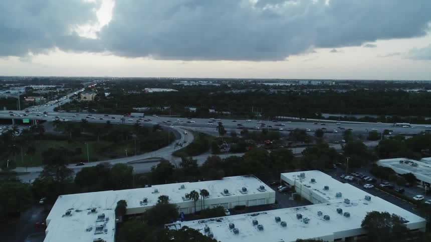 Traffic is flowing on a freeway through a valley during a cloudy day