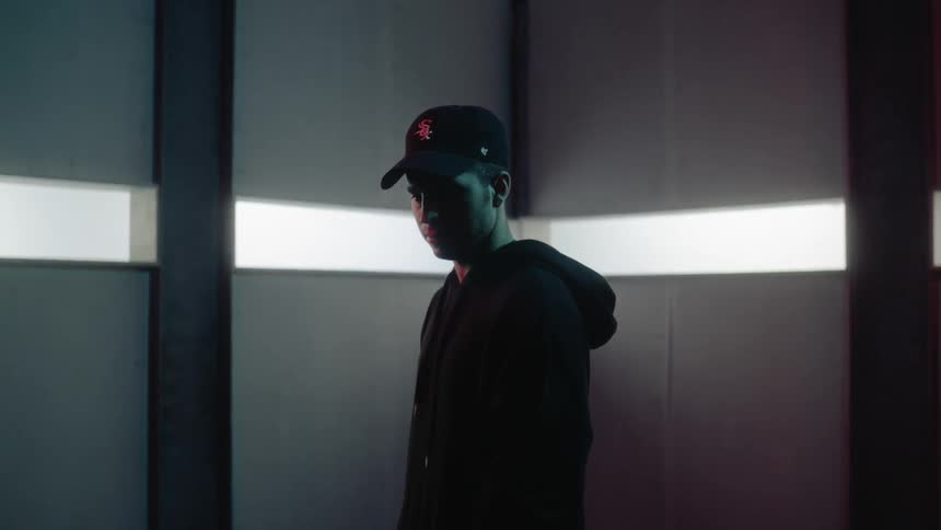 A man stands in a room with narrow windows